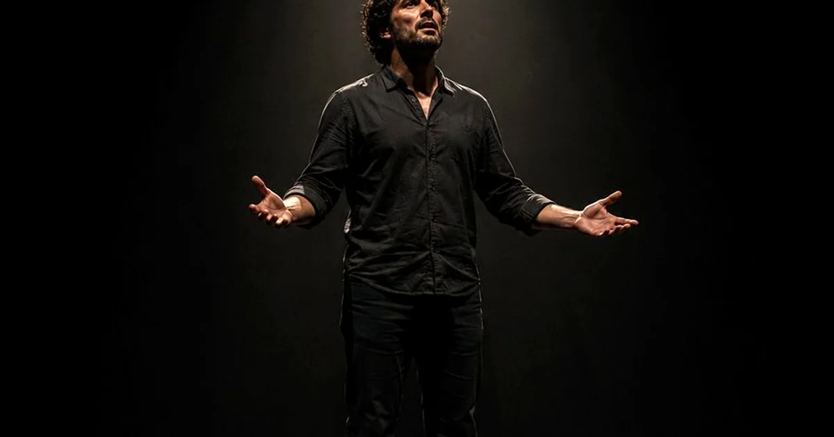 Actor interpretando un monologo en escenario de teatro con iluminacion dramatica